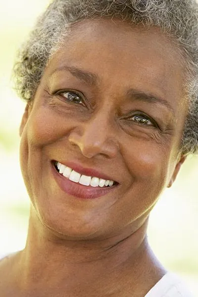 woman showing her dental implants she got from Acre Wood Dental - Gatesville
