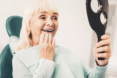 woman with implant-retained dentures from Acre Wood Dental - Round Rock