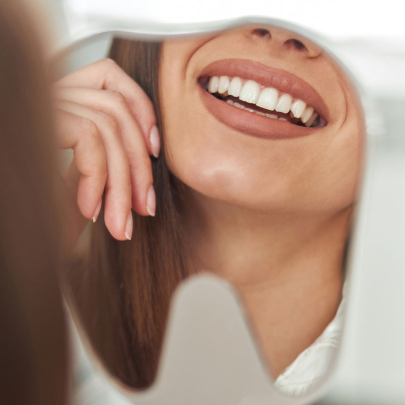 woman loving her smile after visiting Acre Wood Dental in Waco, TX